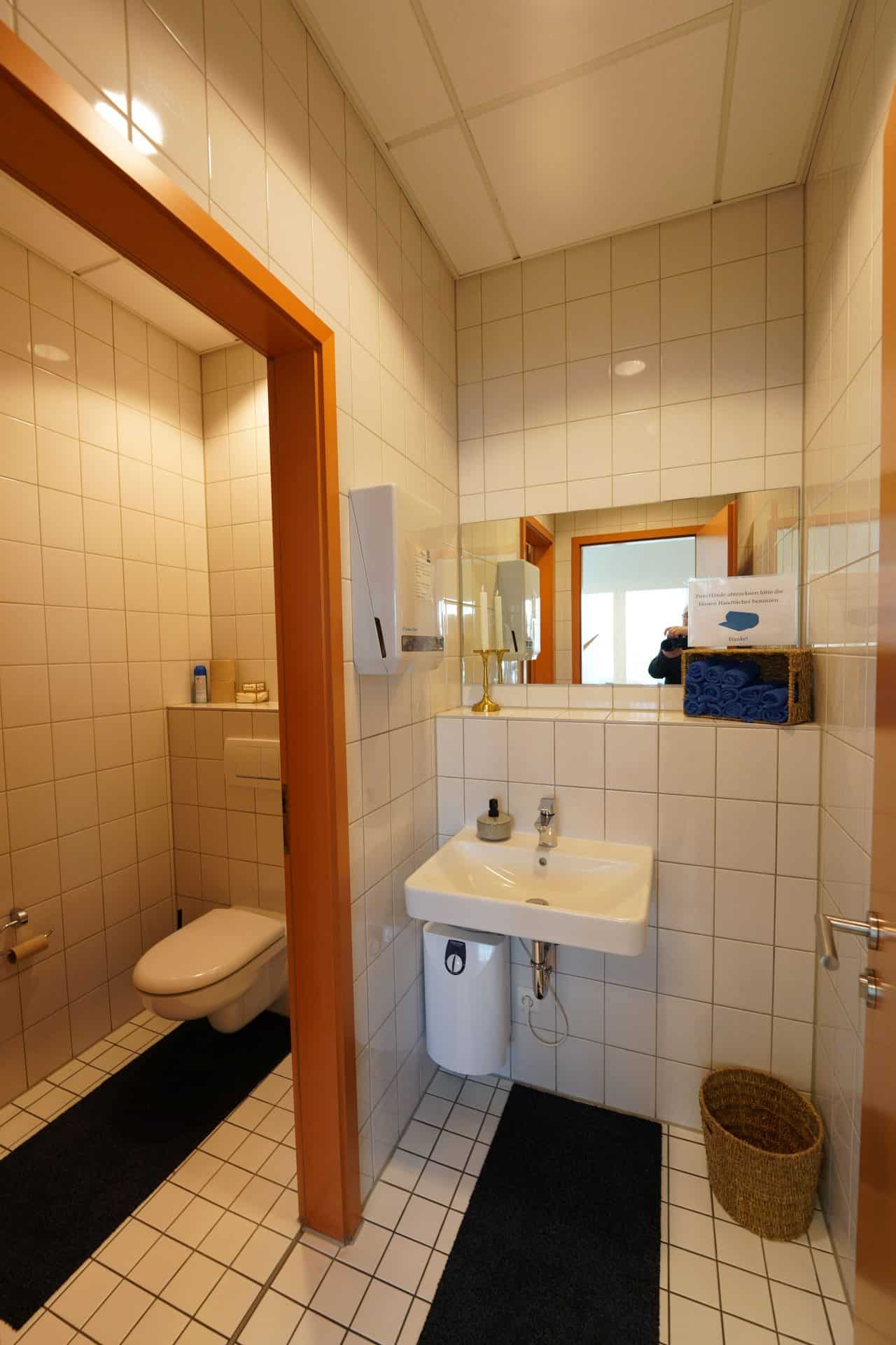 Gefliestes Badezimmer mit Waschbecken und Toilette