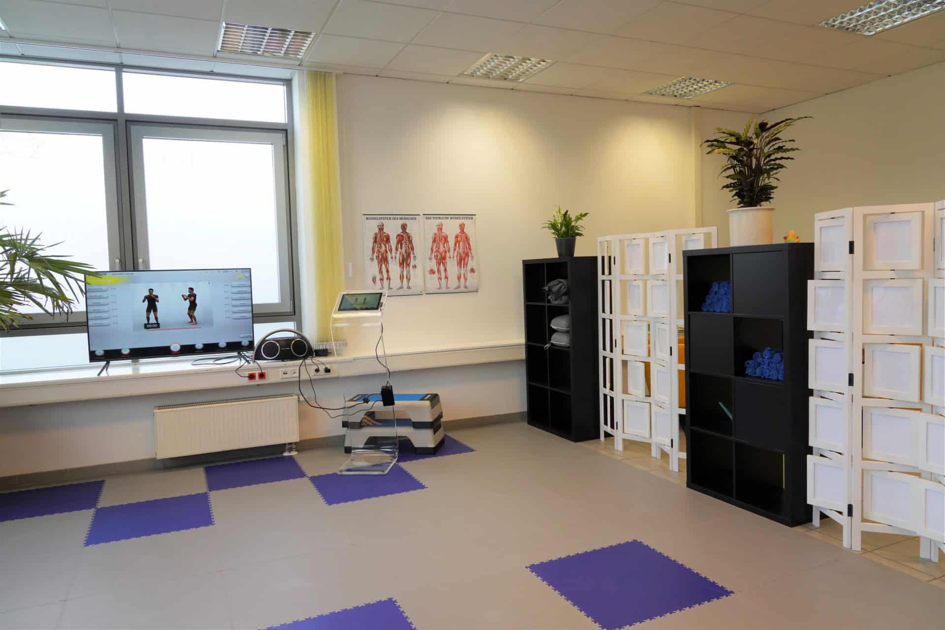 Fitnessraum mit Sportgeräten und Poster an der Wand.