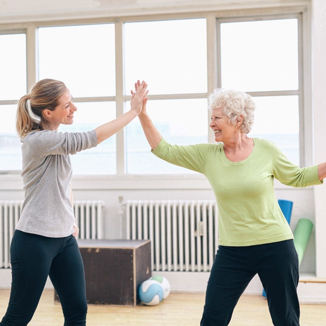Zwei Frauen geben sich ein High-Five beim Sport.