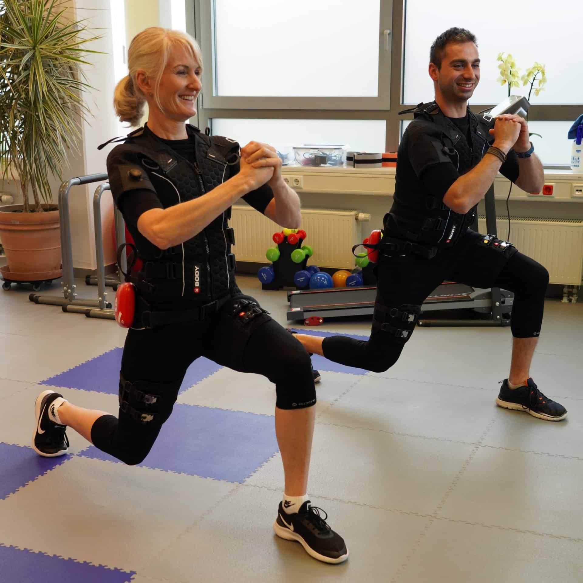 Zwei Personen machen EMS-Training im Fitnessstudio.
